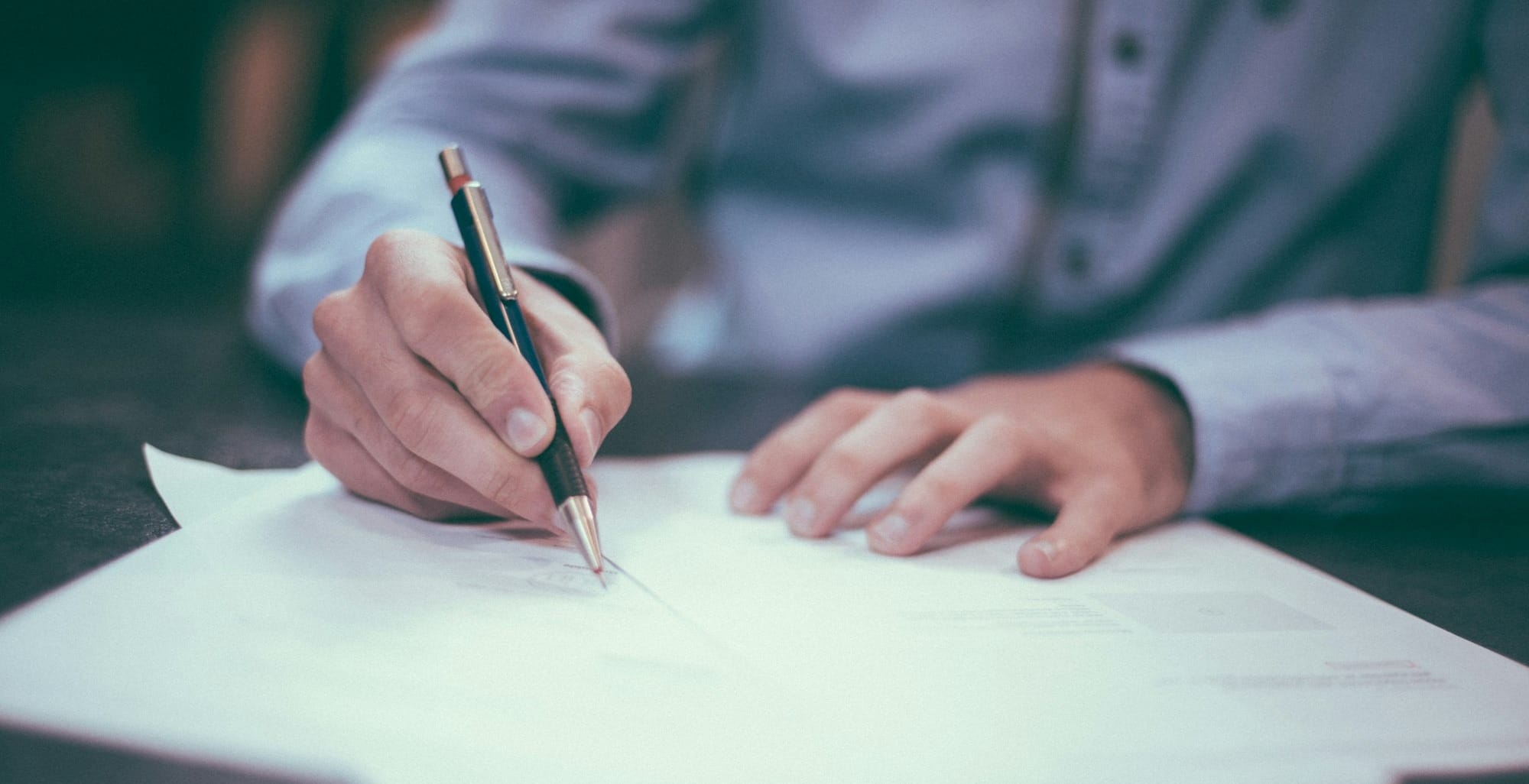 man writing on paper