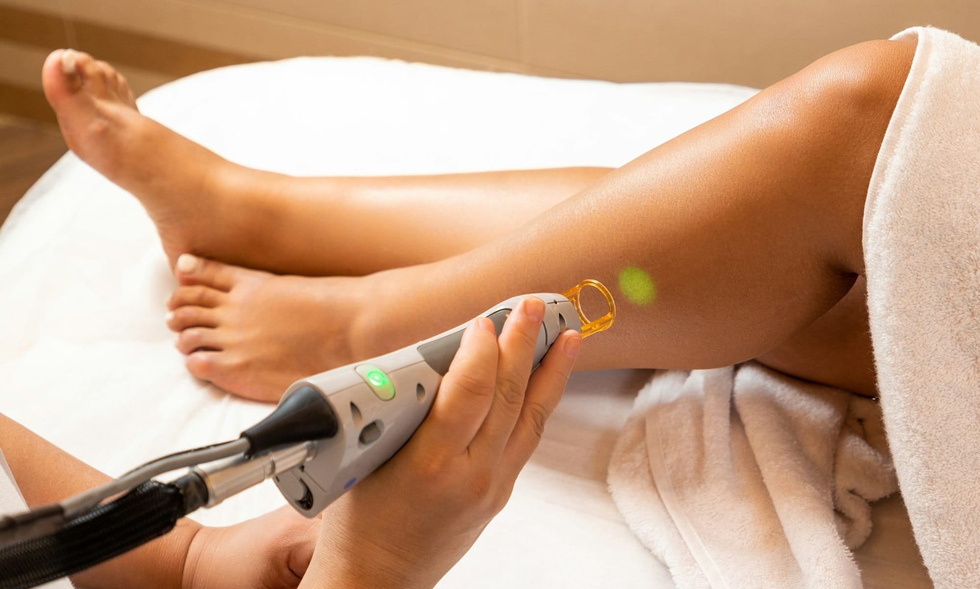 a woman laying on top of a bed with a hair dryer