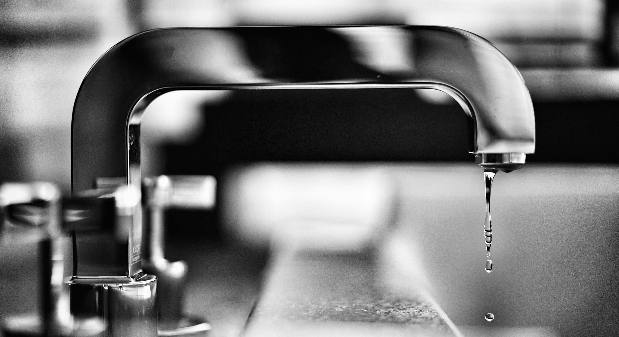 grayscale photography of faucet