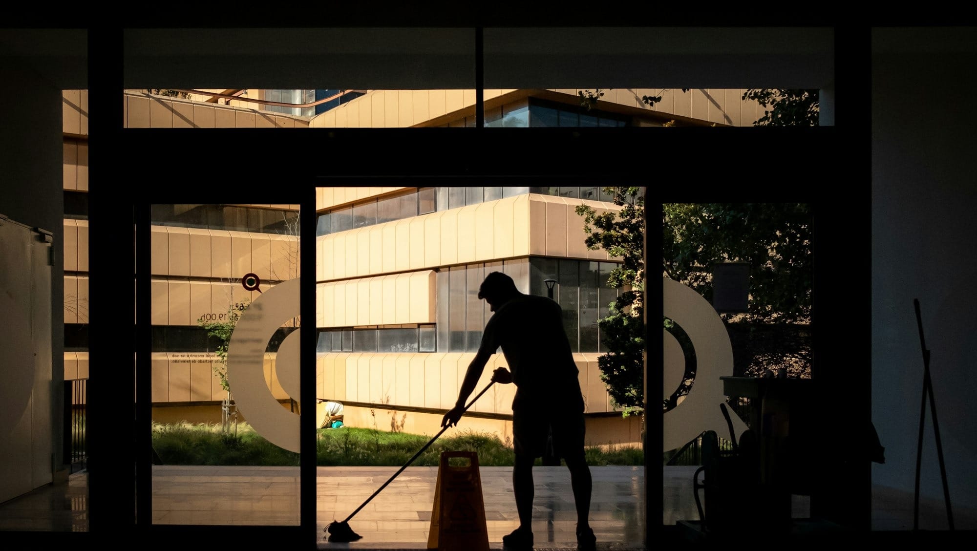 silhouette of man standing near glass window during daytime